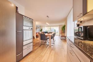 a kitchen with a table and a dining room at Chalet in Thun, modern, spacious, perfect location in Thun