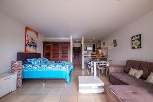a living room with a bed and a couch at Studio Coquet - Mautara Lodge in Bora Bora
