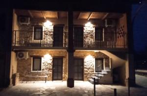 a building with two balconies on the side of it at night at Affittacamere il Gallo Panoramico - Alpine Trekking Stay in Donato