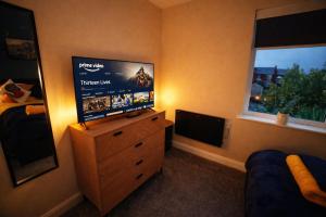 a living room with a television and a dresser with a television at Preston Central in Preston