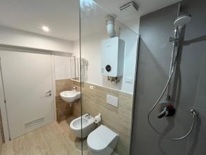 a bathroom with a shower and a toilet and a sink at Casa Furrer in Tirrenia +64 photos