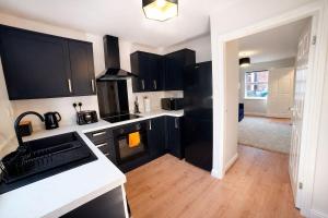 a kitchen with black cabinets and a white counter top at Preston Central in Preston +22 photos