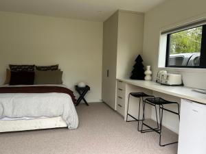 a bedroom with a bed and a desk and a window at Charlie Browns Clyde Studio in Clyde