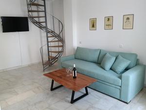 a living room with a blue couch and a table at Phil Samosflats Beachfront Maisonettes in Potokáki