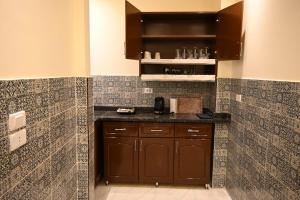 a kitchen with brown cabinets and tiles on the wall at Nabo House in Abu Simbel