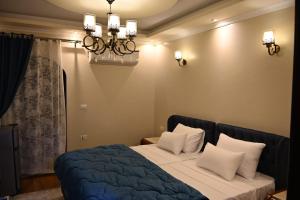a bedroom with a bed and a chandelier at Nabo House in Abu Simbel