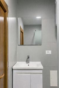 a bathroom with a white sink and a mirror at Serana Stays Modern Rooms with Private Bathroom, Free WiFi & Parking, Central Pejë in Peje +25 photos
