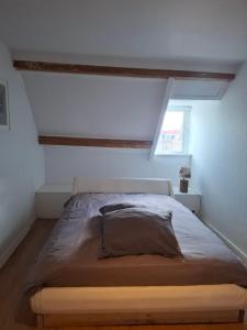 ein Bett in einem weißen Zimmer mit einem Fenster in der Unterkunft markt 1 in Biervliet