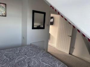 a bedroom with a staircase with a bed and a mirror at Azalea apartments top floor in Sunderland