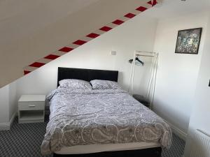 a bedroom with a bed and a staircase at Azalea apartments top floor in Sunderland