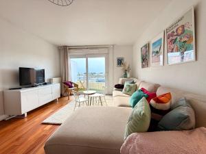 a living room with a couch and a tv at Le cocon des familles - 2 Chambres in Vannes