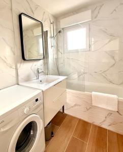 a bathroom with a washing machine and a sink at Le cocon des familles - 2 Chambres in Vannes +24 photos