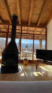 a living room with a fireplace and a large window at Allotjaments rurals Can Punti in Vallfogona de Ripolles