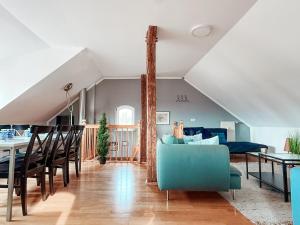 a living room with a blue couch and a table at Sky Maisonette Pirna Altstadt mit 2 Schlafzimmer und extra großem Wohn-Essbereich in Pirna