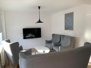 a living room with chairs and a table and a tv at Familiehus in Nakskov