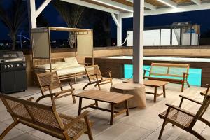 a patio with chairs and a table and a stove at מתחם שמיים ותכלת נתניה in Netanya