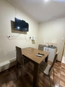 a dining room table with chairs and a television on the wall at Apartamentos Lourdes in Antofagasta +11 photos