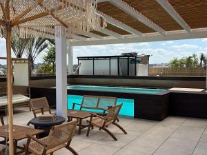 a patio with a swimming pool with chairs and a table at מתחם שמיים ותכלת נתניה in Netanya