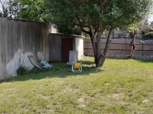 two chairs and a tree in a yard at Ombre d'été in Ruoms