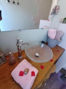 a bathroom sink with red hearts on a wooden table at Ptit Ranch "Ô Rêves Atypiques" spa privatif in Boucé