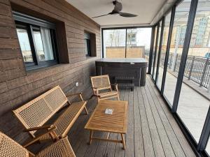 a porch with chairs and a piano on a deck at מתחם שמיים ותכלת נתניה in Netanya