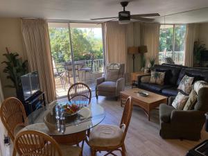 a living room with a couch and a table and chairs at Nani Kai Hale # 204 Hotel District! in Kihei