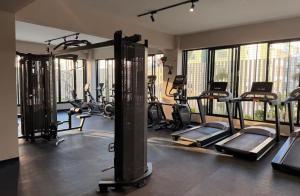 a gym with lots of tread machines and windows at Relaxing & New Retreat 3 bedroom riviera Verde in Santo Domingo