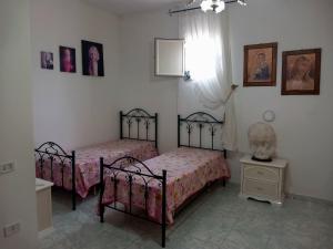 a bedroom with two beds and a window at Casa di Roberto in Porto Cesareo