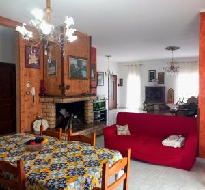 a living room with a table and a red couch at Casa di Roberto in Porto Cesareo +21 photos