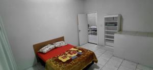 a small bedroom with a bed and a kitchen at Pousada Familiar 09 in Rio do Sul