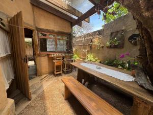 an outdoor patio with a wooden table and bench at Chalé João de barro in Bonito