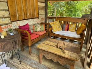 a porch with two chairs and a couch and a table at Chalé João de barro in Bonito +17 photos