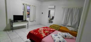 a room with a couch and a table and a television at Pousada Familiar 09 in Rio do Sul