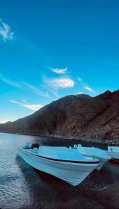 a boat sitting on the shore of a body of water at Dahab Panorama Villa Private Pool in Dahab