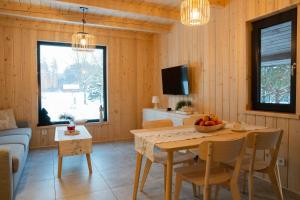 a living room with a table with chairs and a television at Siedlisko Gruszeczki in Gruszki