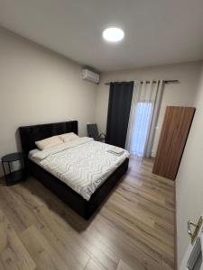 a bedroom with a bed and a wooden floor at Hostel Villa EFES Private Rooms in Tirana