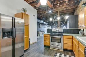 a kitchen with a stainless steel refrigerator and wooden cabinets at Jacuzzi Tub & Full Kitchen: Dowtown Hannibal Loft in Hannibal