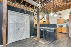 a kitchen with white doors and a bar with stools at Jacuzzi Tub & Full Kitchen: Dowtown Hannibal Loft in Hannibal +17 photos