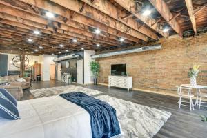a bedroom with a bed and a brick wall at Jacuzzi Tub & Full Kitchen: Dowtown Hannibal Loft in Hannibal