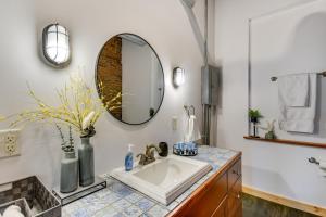 a bathroom with a sink and a mirror at Jacuzzi Tub & Full Kitchen: Dowtown Hannibal Loft in Hannibal