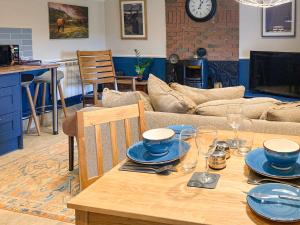 a table with plates and glasses on it in a living room at Taigh Violet Rose in Gramisdale