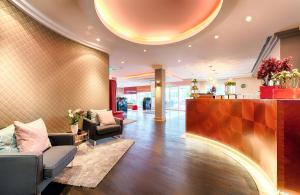 a lobby of a hotel with couches and a bar at Leonardo Hotel Heidelberg in Heidelberg