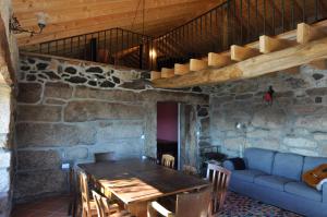 a dining room with a table and a couch at Casa do Alto Montalegre in Montalegre