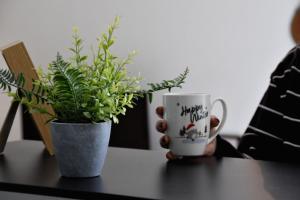a table with two plants and a coffee cup on it at La Cachette Ludique in Orléans