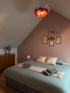 a bedroom with a large bed with towels on it at Blanche maison calme in Neuville-sur-Vanne