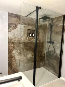 a shower with a glass door in a bathroom at Blanche maison calme in Neuville-sur-Vanne +25 photos