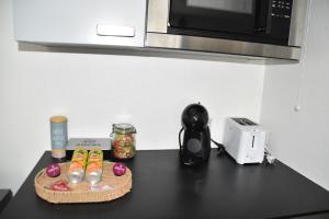 a black counter with a microwave and a toaster at La Cachette Ludique in Orléans