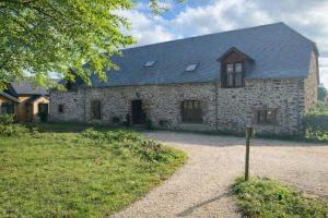 a stone house with a pathway leading to it at La grange de Moli in Vigeois