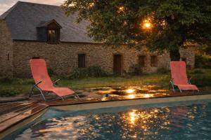 two chairs sitting in front of a swimming pool at La grange de Moli in Vigeois
