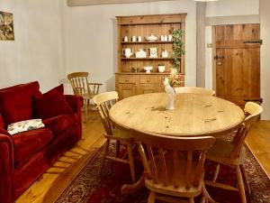 a living room with a table and a red couch at La grange de Moli in Vigeois